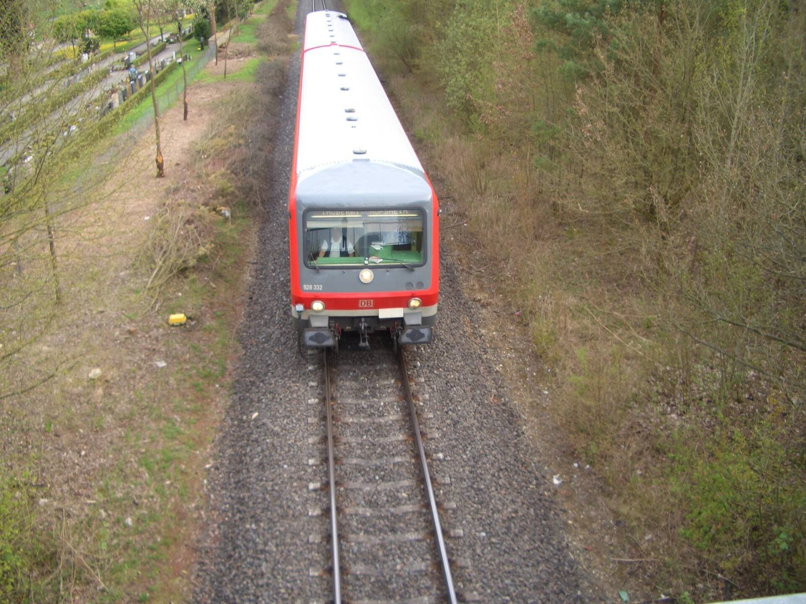 A red and white regional train on the Tauber valley railway between vineyards and fields