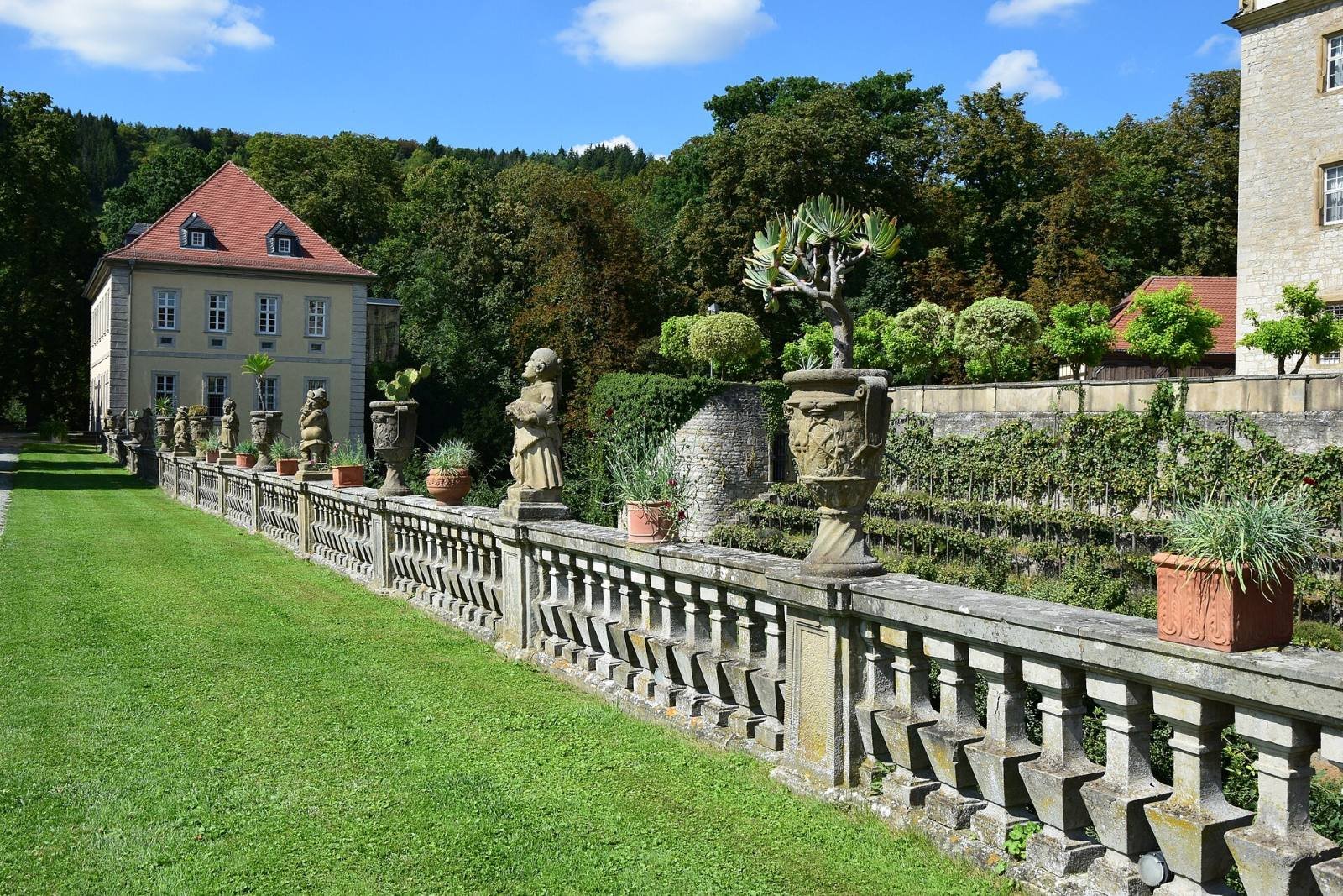 Stone dwarf figures and urns on the balustrade of the gallery of dwarfs in the Weikersheim palace garden